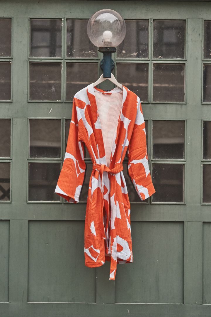 Från Marimekko kommer det berömda blommiga mönstret Unikko av Maija Isola som klär allt från inredningsdetaljer till textilier, här på våfflad badrock i orange och ljusblått.