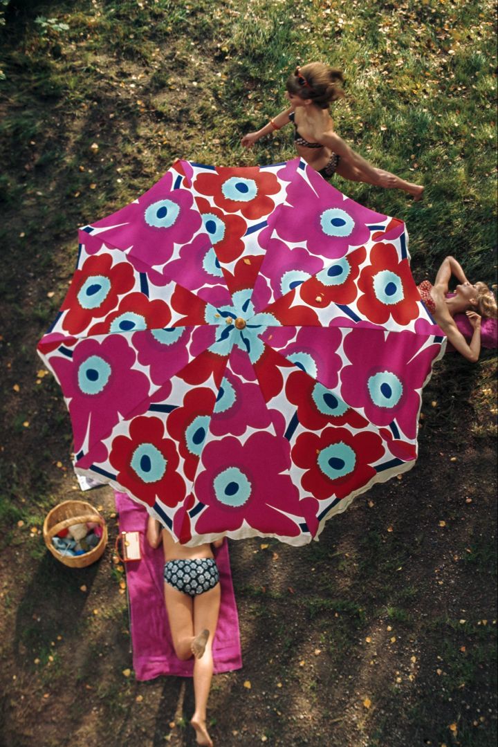 År 2024 firar Unikko-mönstret från Marimekko 60 år, det firas genom en rad olika event och en jubileumskollektion som hyllar den ikoniska vallmoblomman. Här en gammal bild från Marimekkos arkiv som visar ett Unikko-parasoll.
