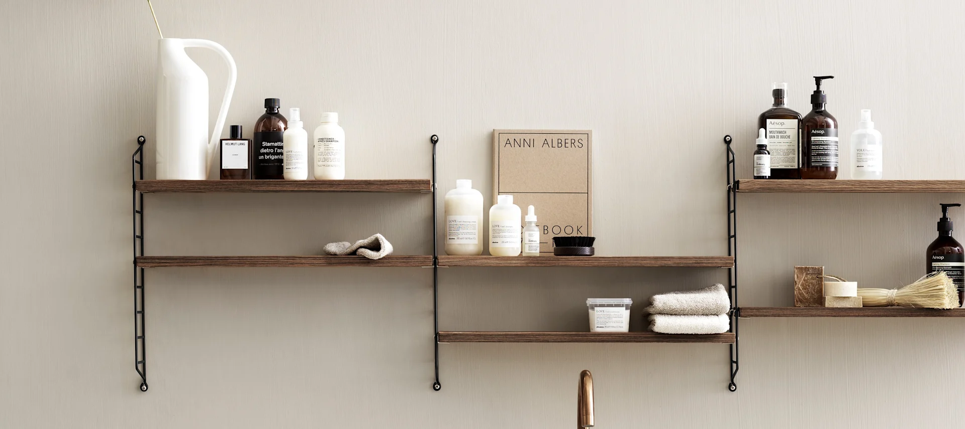 Guide för din stringhylla hos Svenssons - här tre String Pocket i valnöt uppsatta i ett badrum.