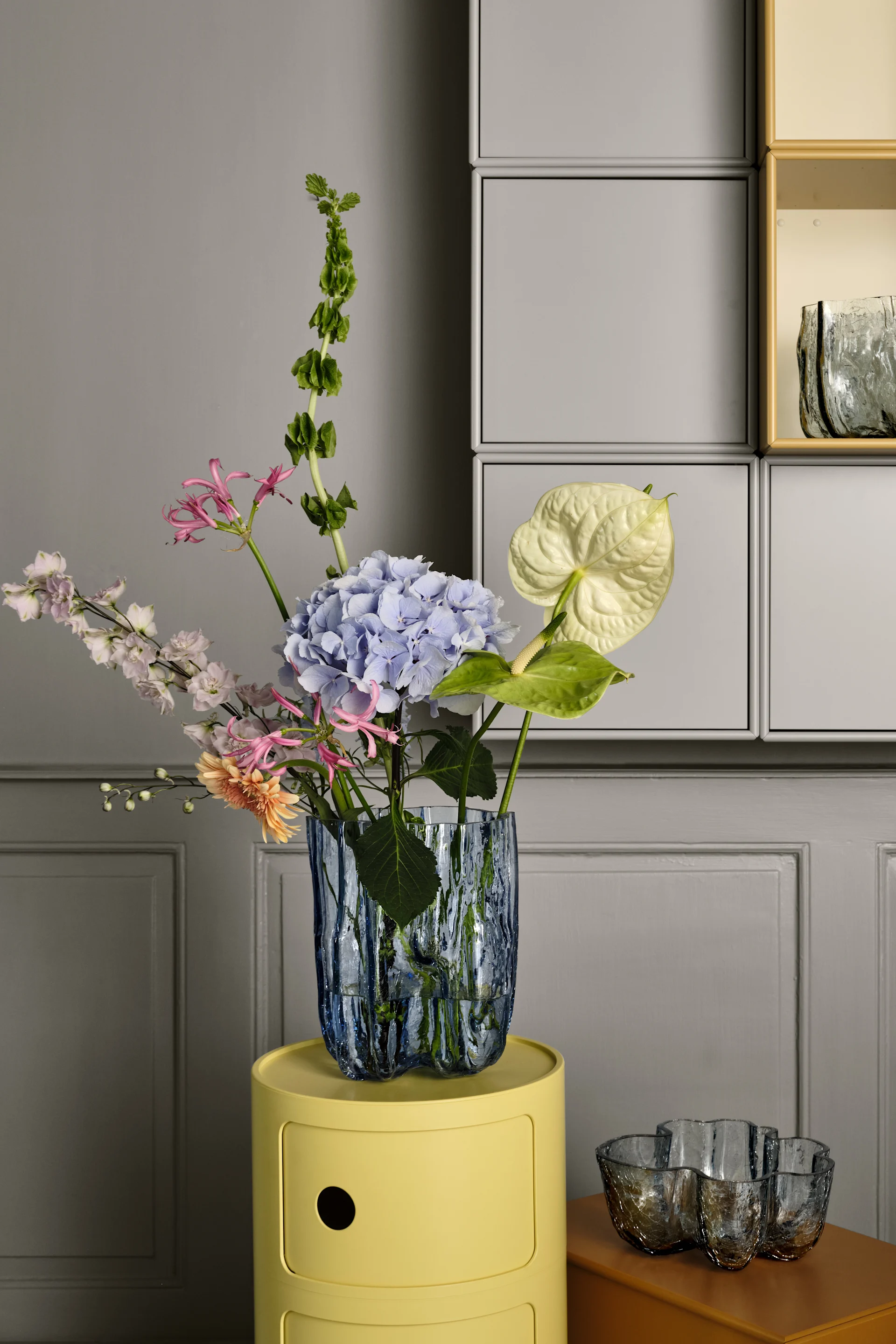 Crackle vas från Kosta Boda, här i cirkulärt glas som ger den en ljusblå ton är formgiven av Åsa Jungnelius med en teknik som ger ett krackelerat glas. Vasen är perfekt att ge bort i studentpresent då den blir en fin inredningsdetalj både med och utan blommor.