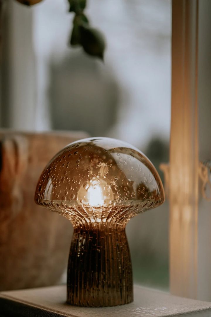 Bild som visar Fungo bordslampa i brunt glas från Globen Lighting. Lampan har formen av en skivlingsvamp och för tankarna till skogen.