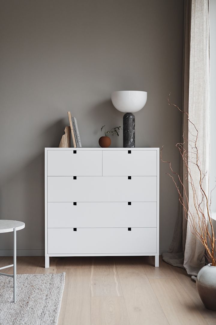 Square byrå med 5 lådor i vitt från varumärket 1898 är en av de mest populära möblerna som finns i flera storlekar och färger. Här placerad i vardagsrum med Kizu bordslampa från New Works ovanpå.