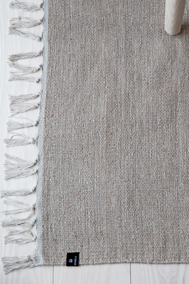 Välj rätt matta, bild som visar Särö bomullsmatta från varumärket Himla, en tunn fin matta i enfärgad bomull med vita fransar, här i den ljusgråa färgen concrete.
