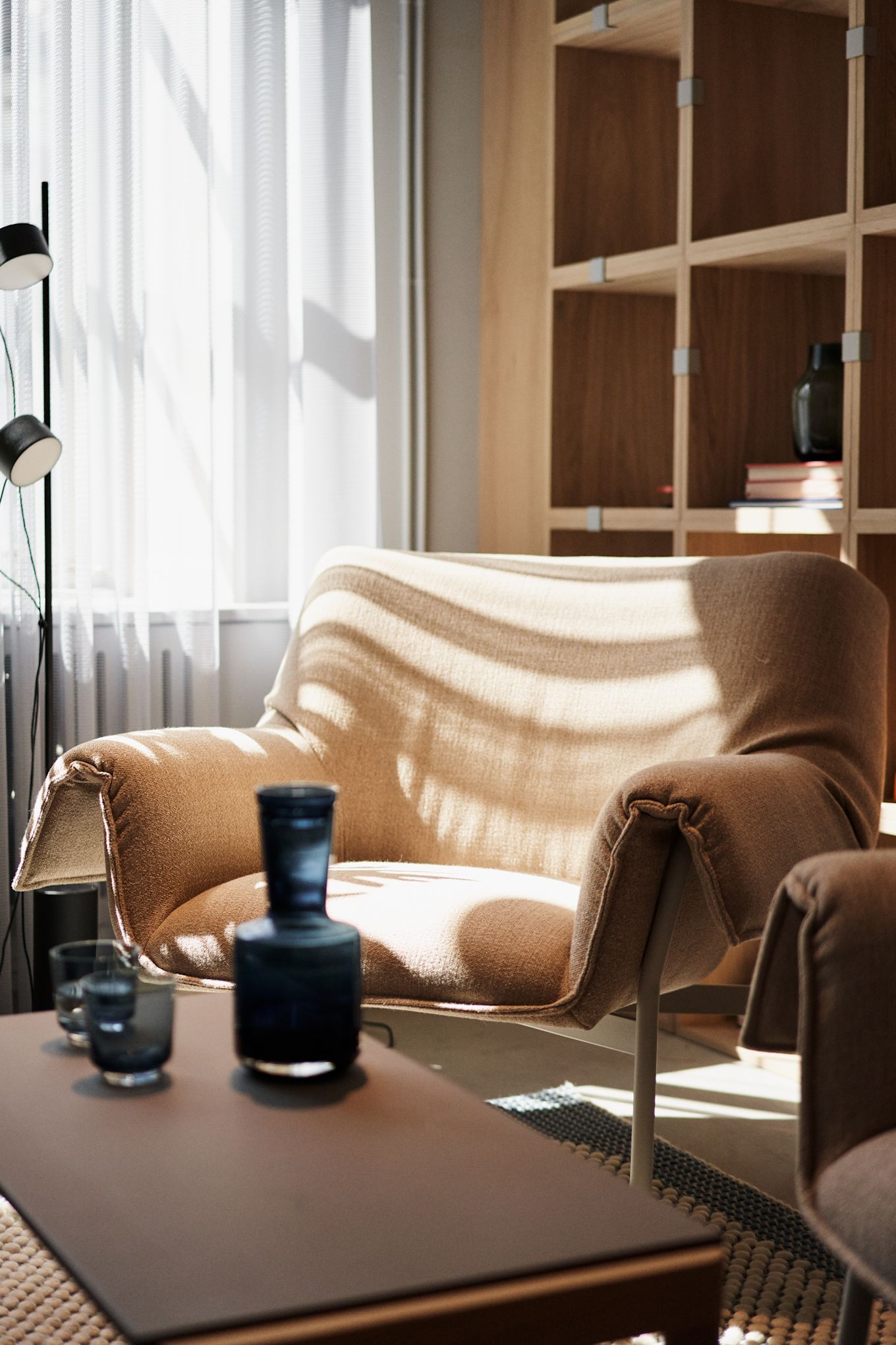 Ett annat exempel på en bullig och mjuk fåtölj som går hand i hans med höstens inredning 2023 är Wrap lounge chair från Muuto, här i ett linnetyg med vitt underrede i stål.