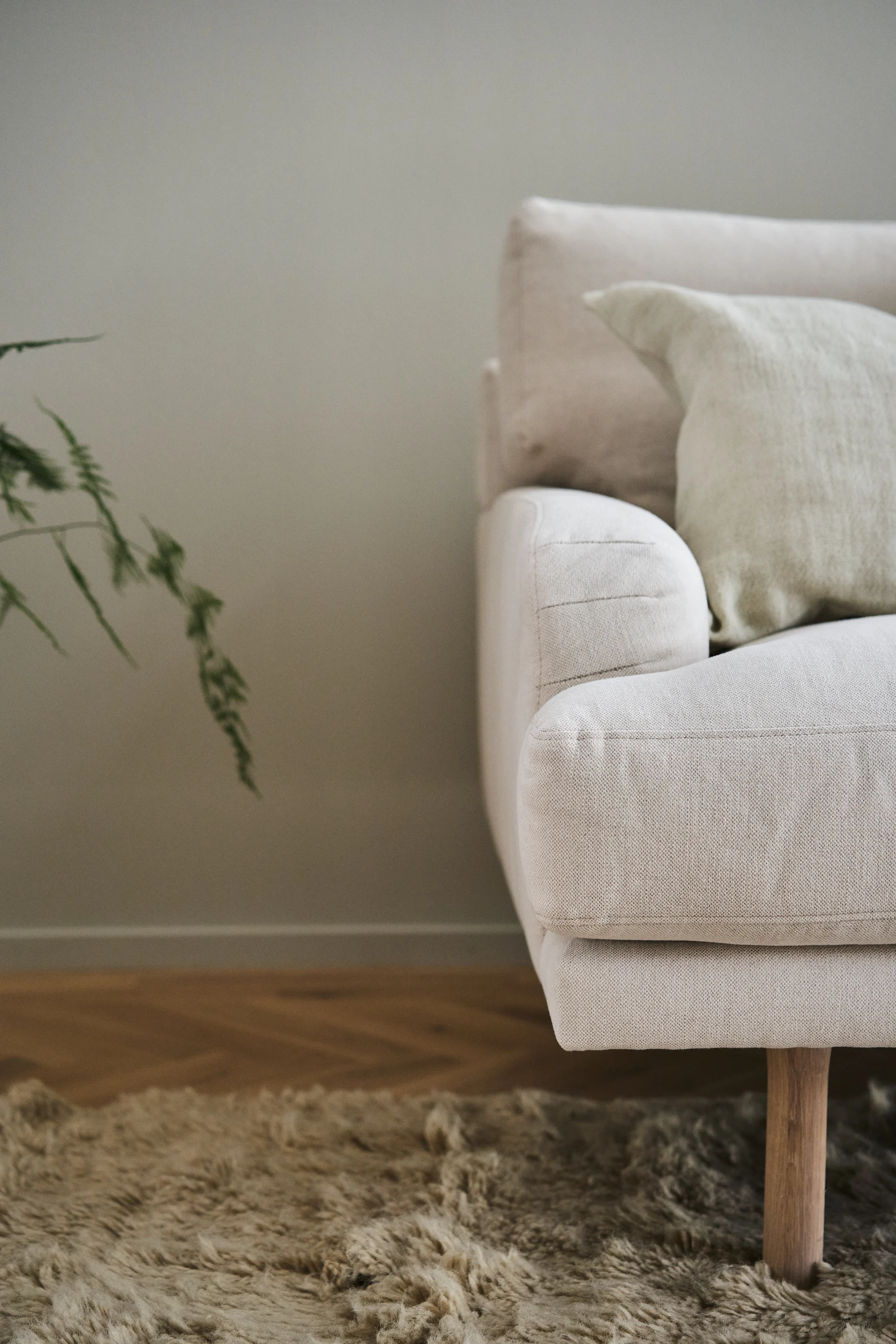 Lidnäs soffa i beige från varumärlet 1898, närbild på armstöd och ben.