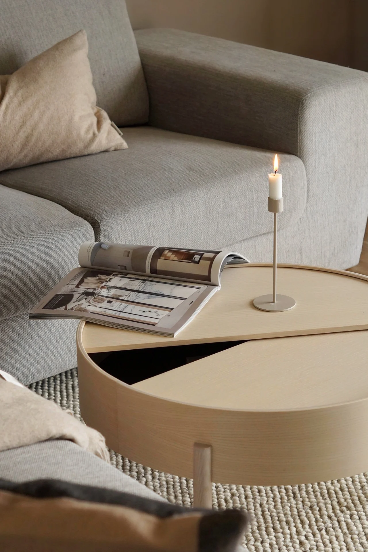 Så väljer du rätt soffbord, bild som visar det runda soffbordet Arc från Woud, här i materialet ask. Det runda soffbordet med förvaring i står placerat på en grön matta.