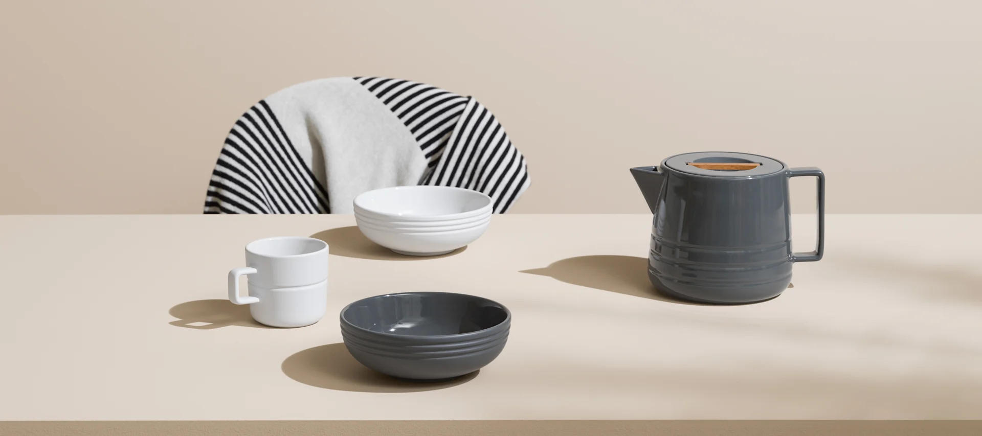 NJRD-porslin i grått och vitt och en NJRD-pläd i grafiskt svartvitt. 