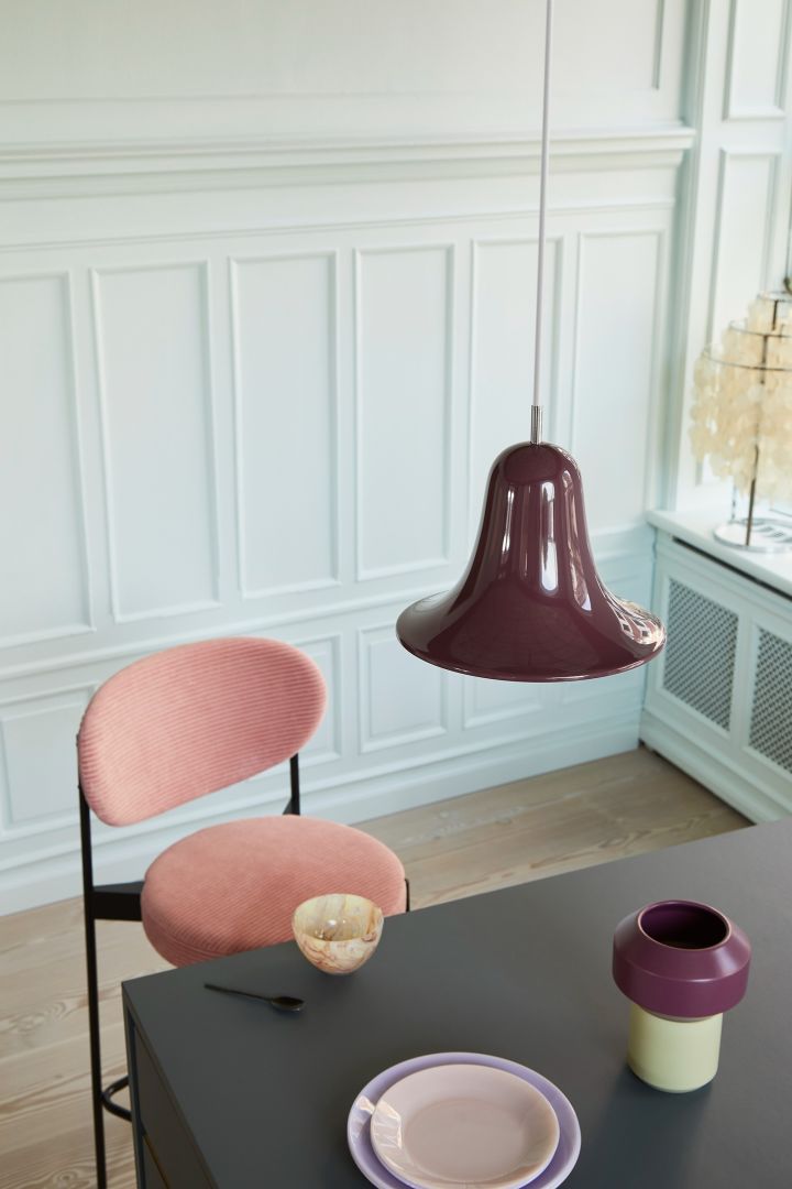 Pantop taklampa i vinrött från Verpan, här hängandes över mörkbetsat matbord tillsammans med rosa stol.