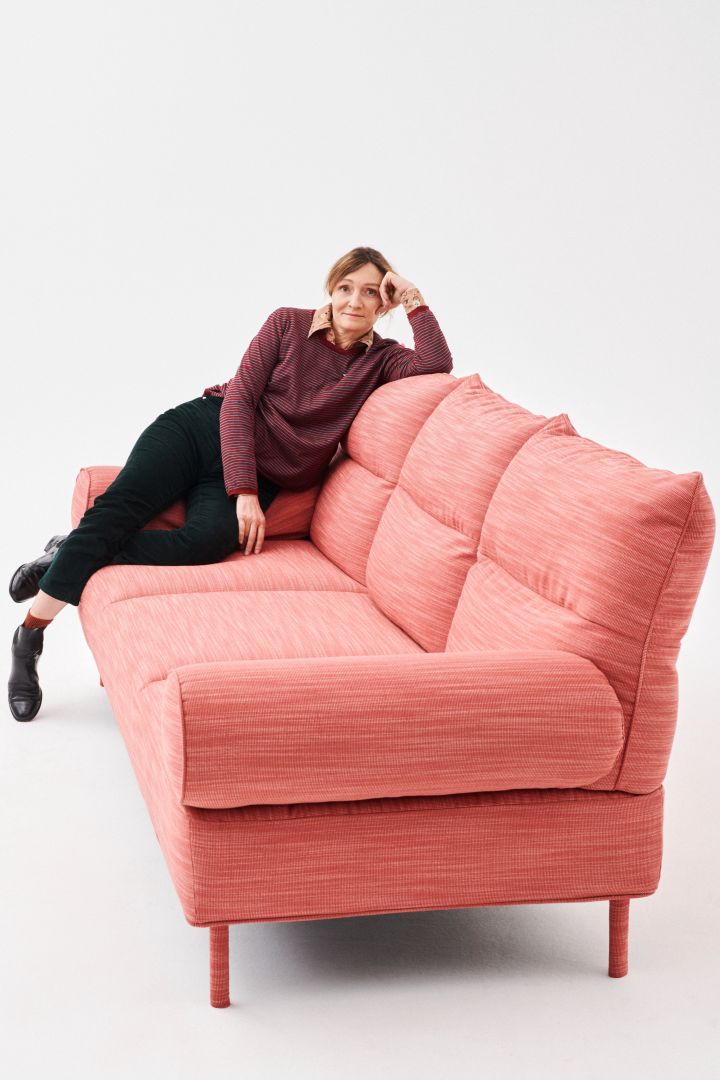 Bild som visar formgivaren Inga Sempé sittandes i rosa Pandarine-soffa.