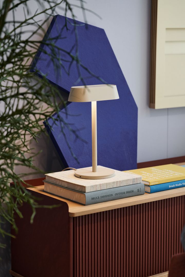 Bild som visar Linear bordslampa i ljusgrått, placerad på Enfold sidobord.