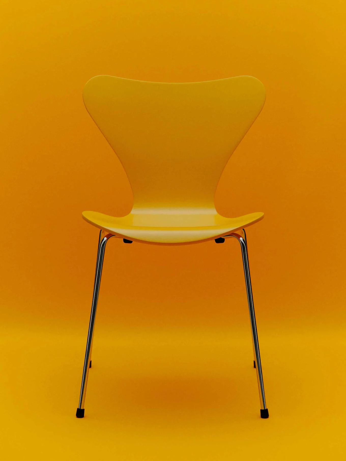 Gul stol med kromben mot en gul bakgrund.