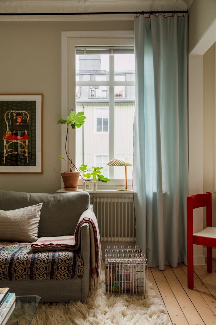 I vardagsrumsfönstret står den ikoniska 5321 bordslampan från Gubi, tillverkad i mässing.