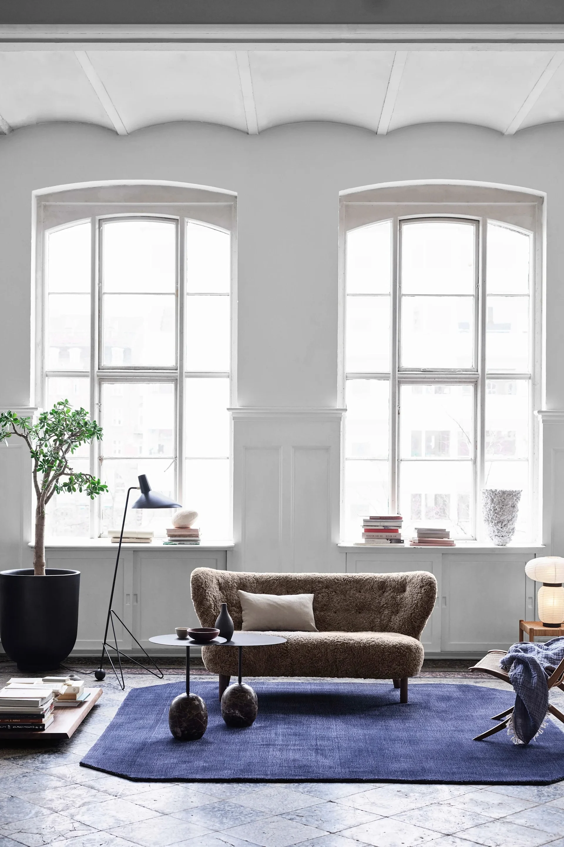 Little Petra soffa i fårskinn från &Tradition är en klassisk, svängd liten soffa med fast stoppning, högt ryggstöd och ben i trä.