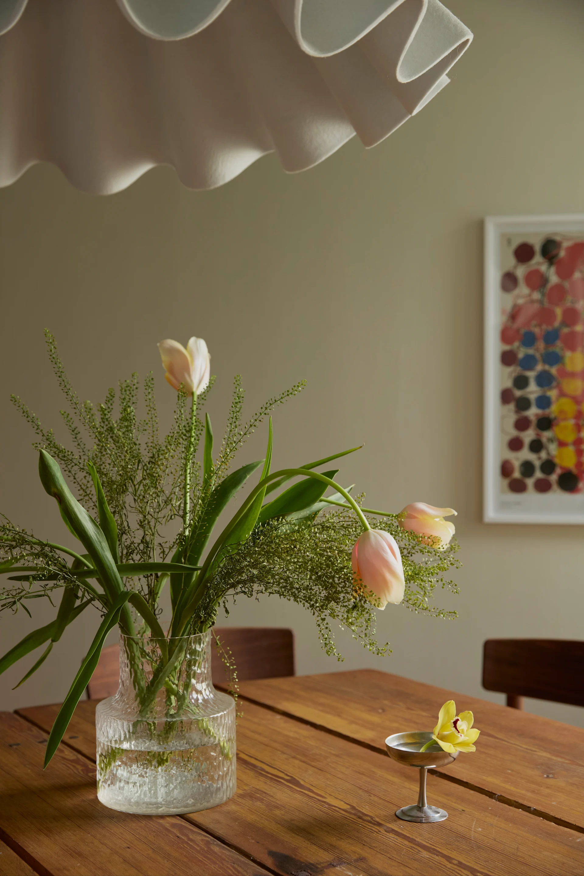 På det vackra, rustika träbordet står Kolonn vas från Skrufs Glasbruk och bredvid den lilla glasskålen i rostfritt stål från HAY.
