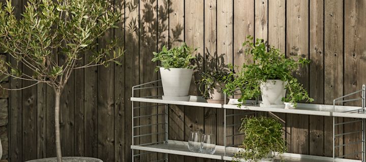 Utomhuskrukor i grå terrakotta från HAY placerade på stringhylla utomhus.