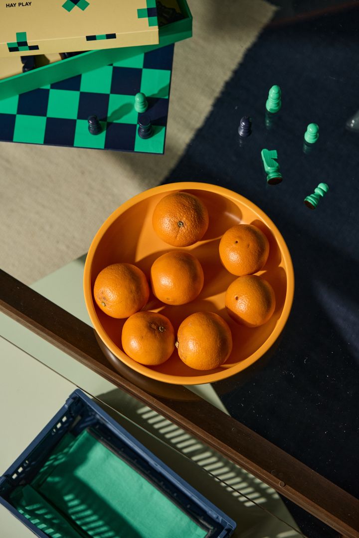 Bild som visar Sobremesa serveringsskål i färgen gul från HAY. Skålen står på ett glasbord och i skålen ligger små apelsiner.