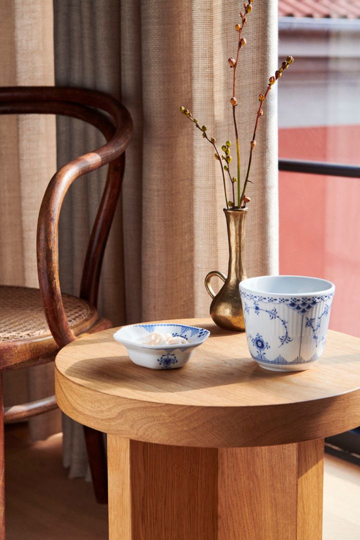 Blue Elements mugg från Royal Copenhagen på litet träbord, blåvitt porslin av högsta kvalitet.