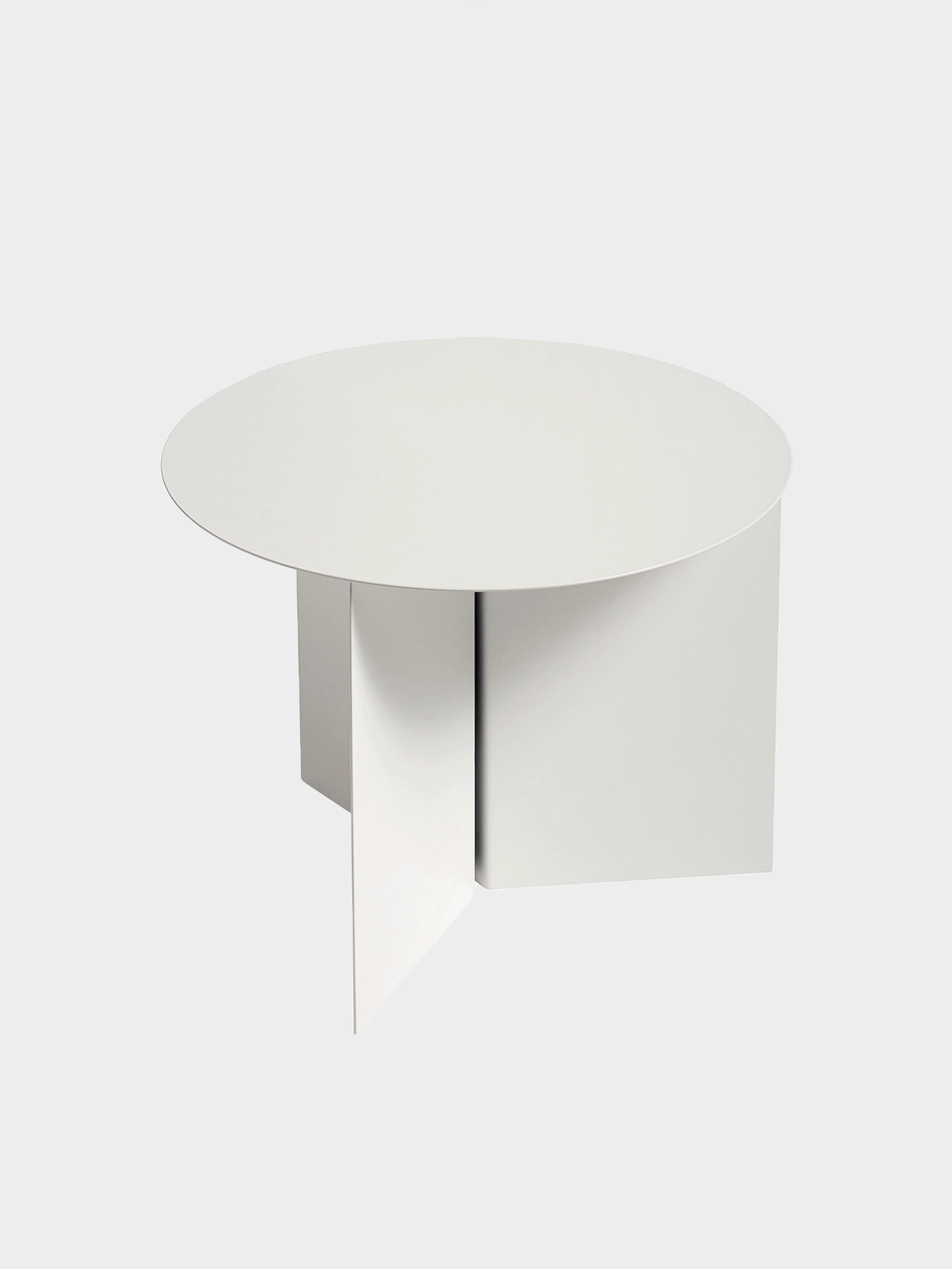 Vitt, runt soffbord med en geometrisk bas bestående av tre paneler.