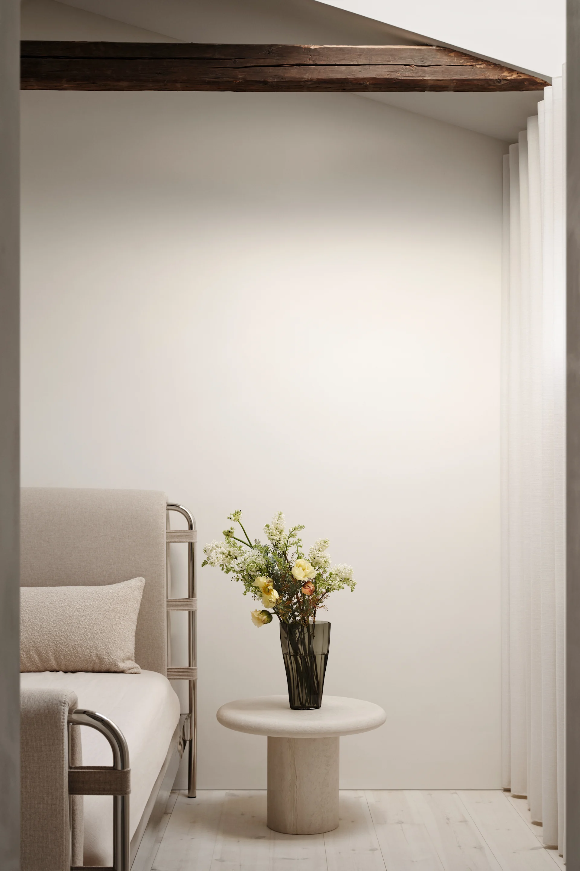 Bild som visar Reed-vasen 30 cm mossgrön placerad på ett nattduksbord av sten, i vasen är en vild blombukett placerad. Vasen är formgiven av Monica Förster för Orrefors.