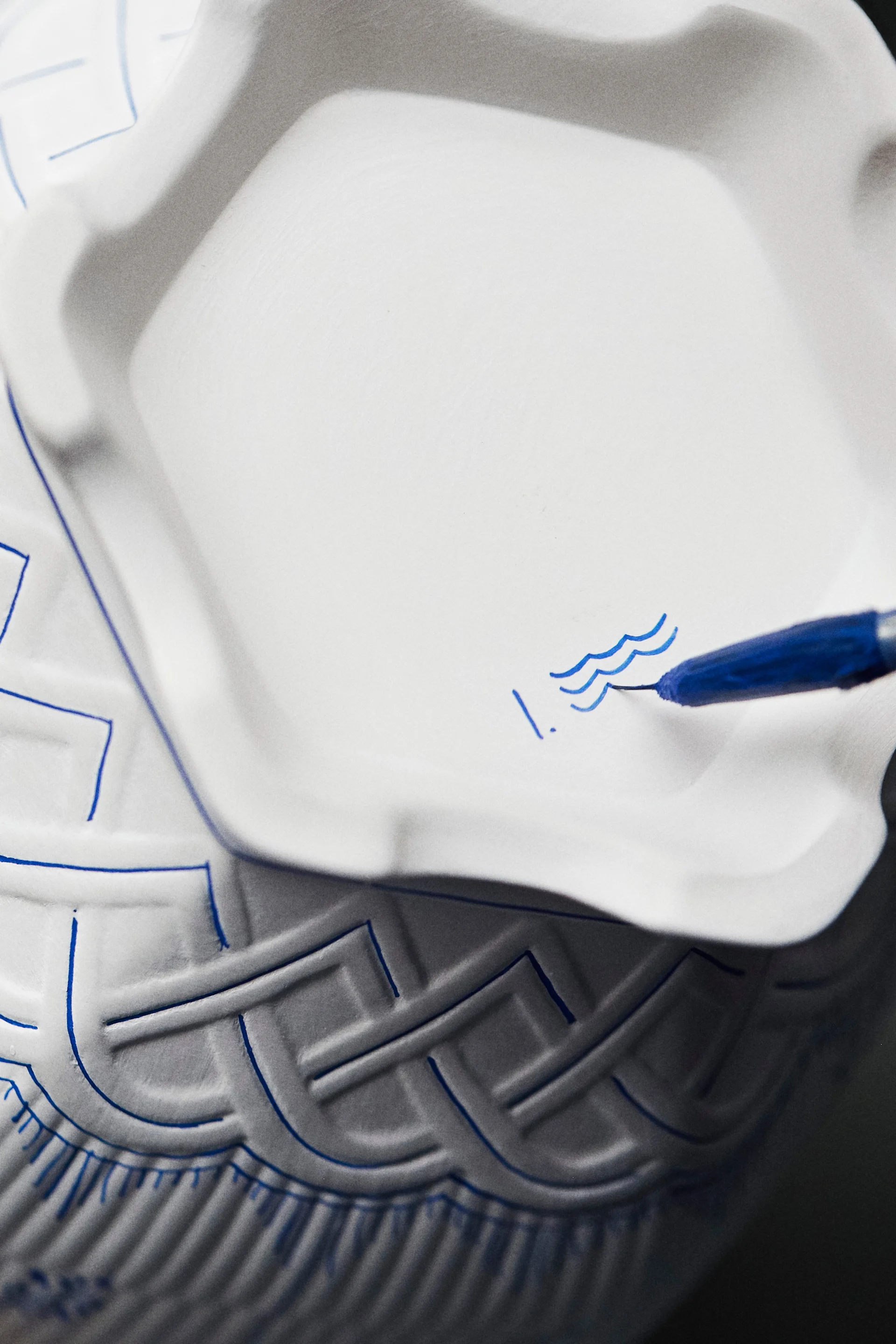 Handmålning av signatur på Royal Copenhagens blåvita porslin.