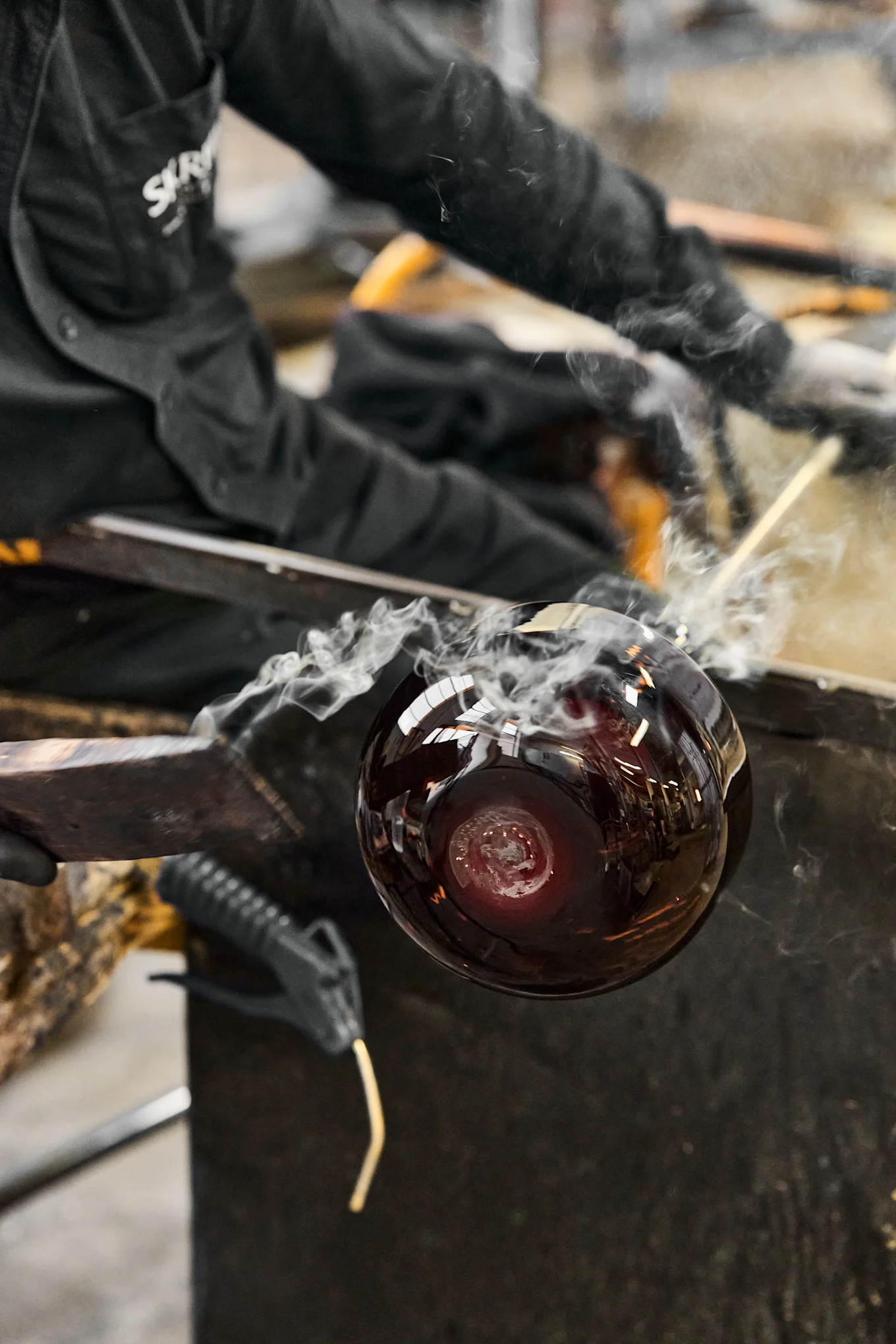 Bild som visar en Drummel-vas under tillverkning i glashyttan, här rykande varm från värmen i ugnen.