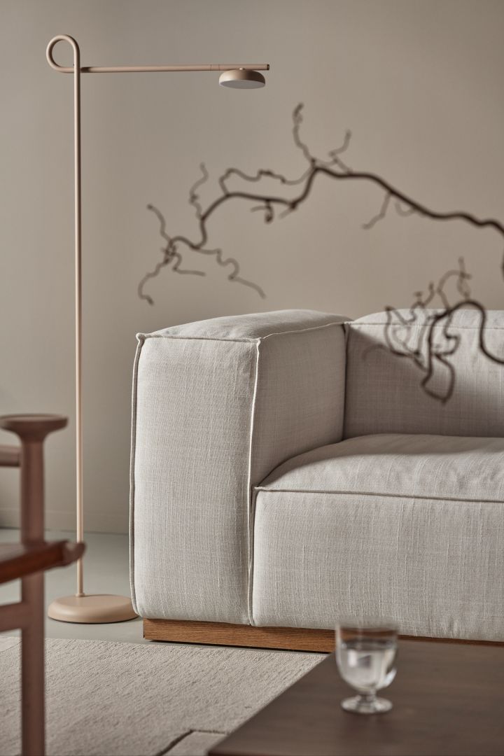 Salto golvlampa i beige från Northern är en minimalistisk variant på snygga golvlampor som passar in i de allra flesta hem, här placerad bredvid en beige soffa som läslampa.
