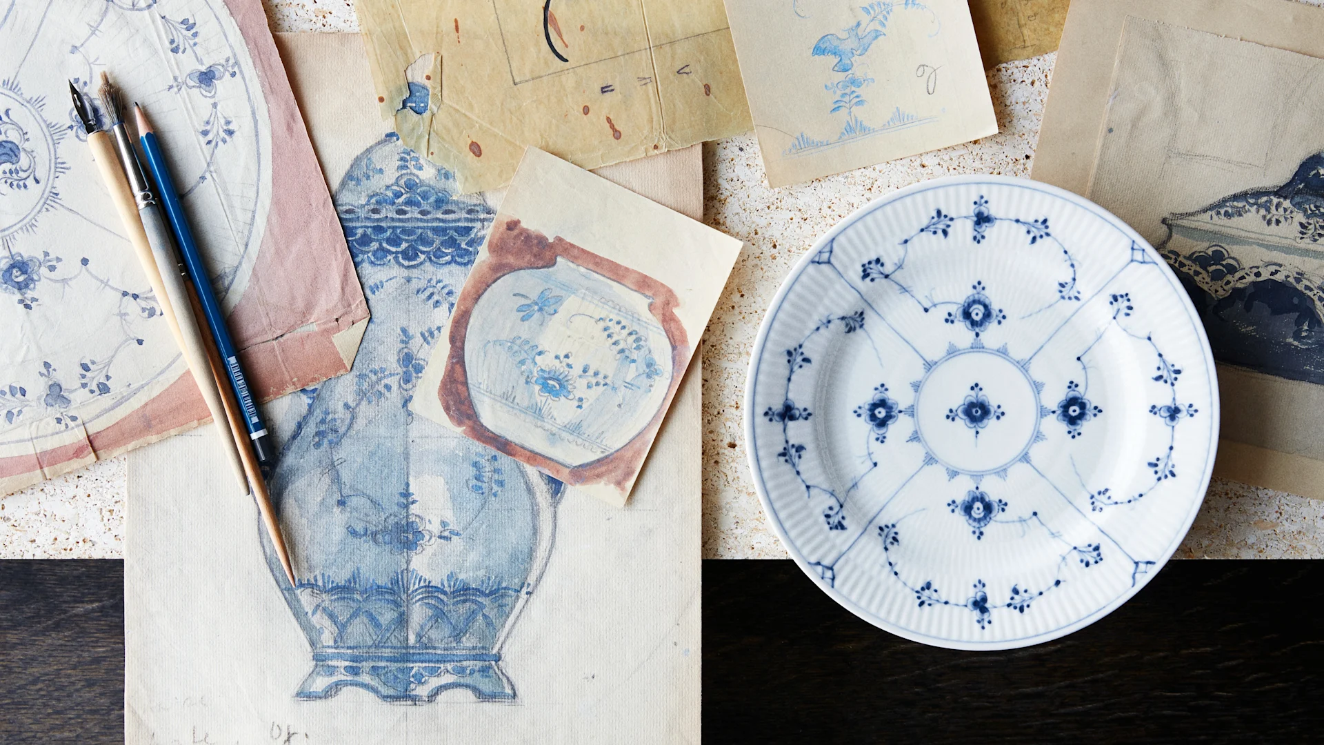 Musselmalet tallrik och skisser på blåvitt porslin från Royal Copenhagen.