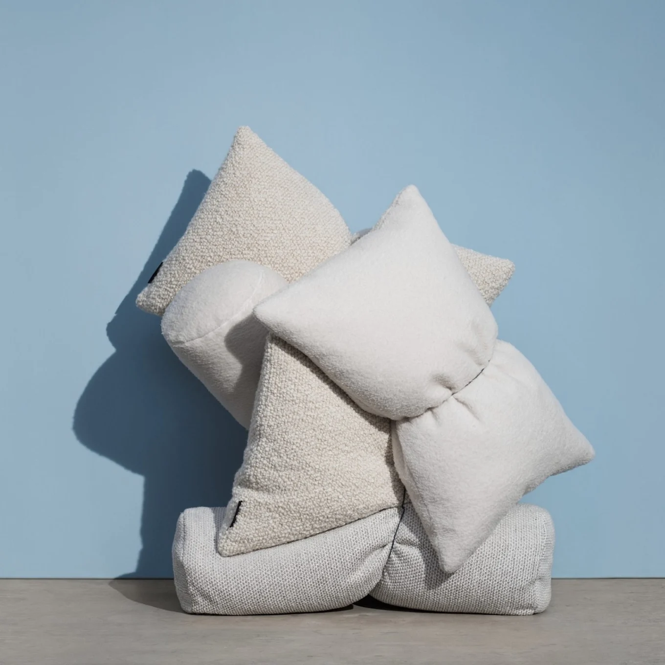 Saturday kuddar från Massproductions samlade i hög mot blå bakgrund