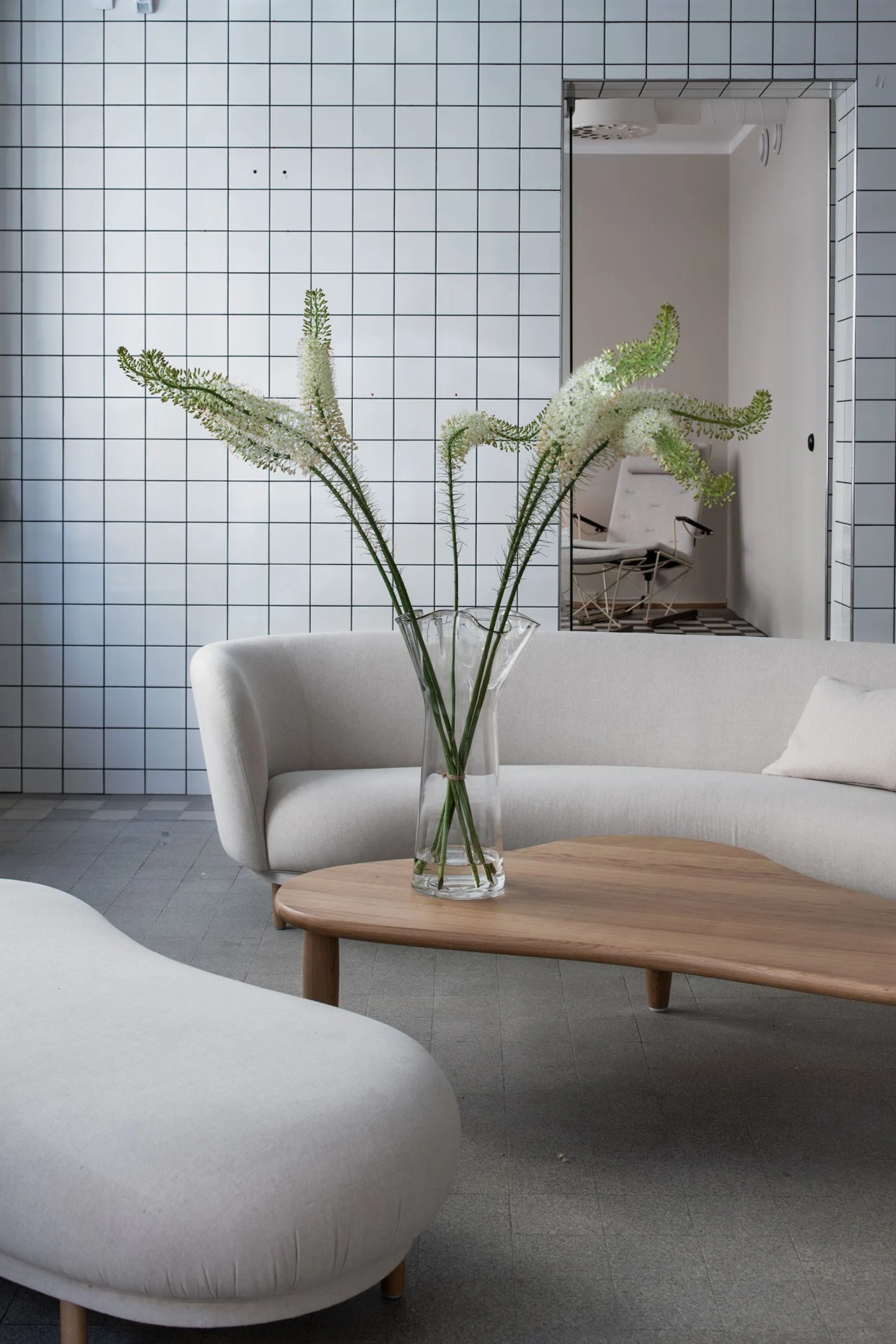 Dandy ottoman och soffa i vitt från Massproductions placerade mot helkaklad bakgrund