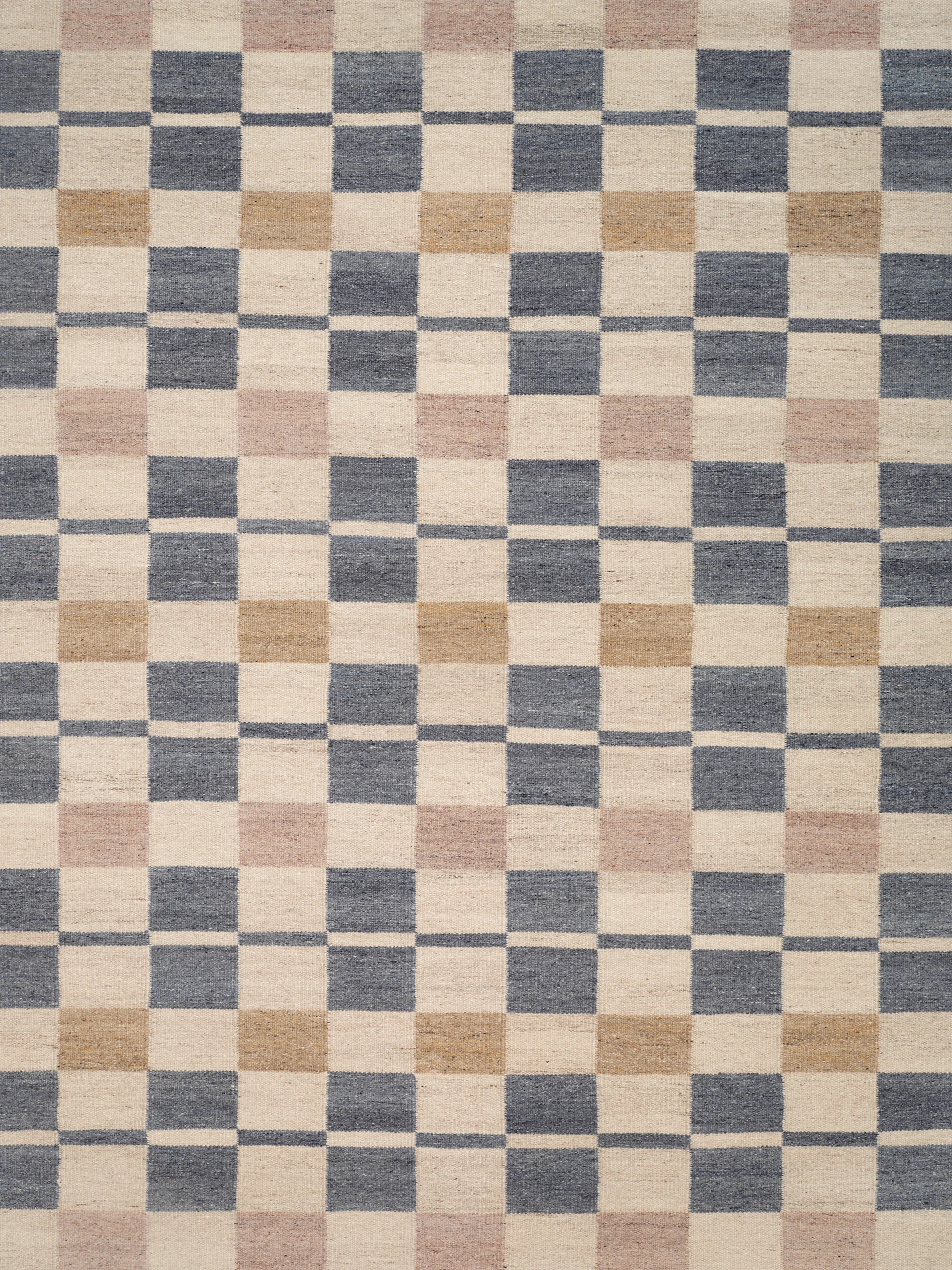 Rutig matta i benvitt, mörk gråblått, ljust brunt och ljust rosa.