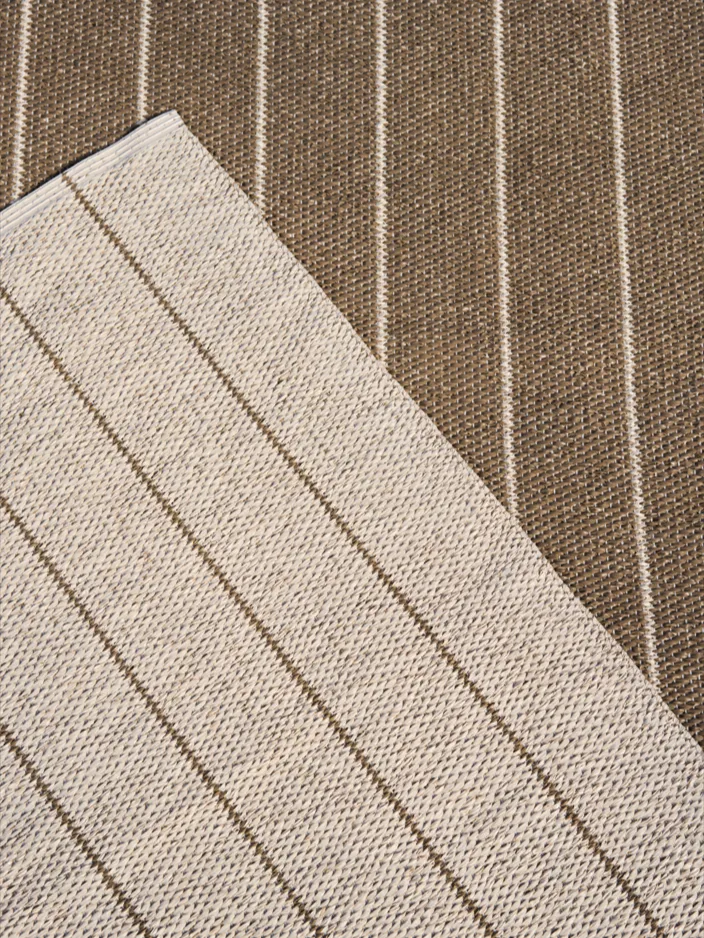 Randigt tyg i beige med bruna ränder, diagonalt över brunt tyg med beige ränder.