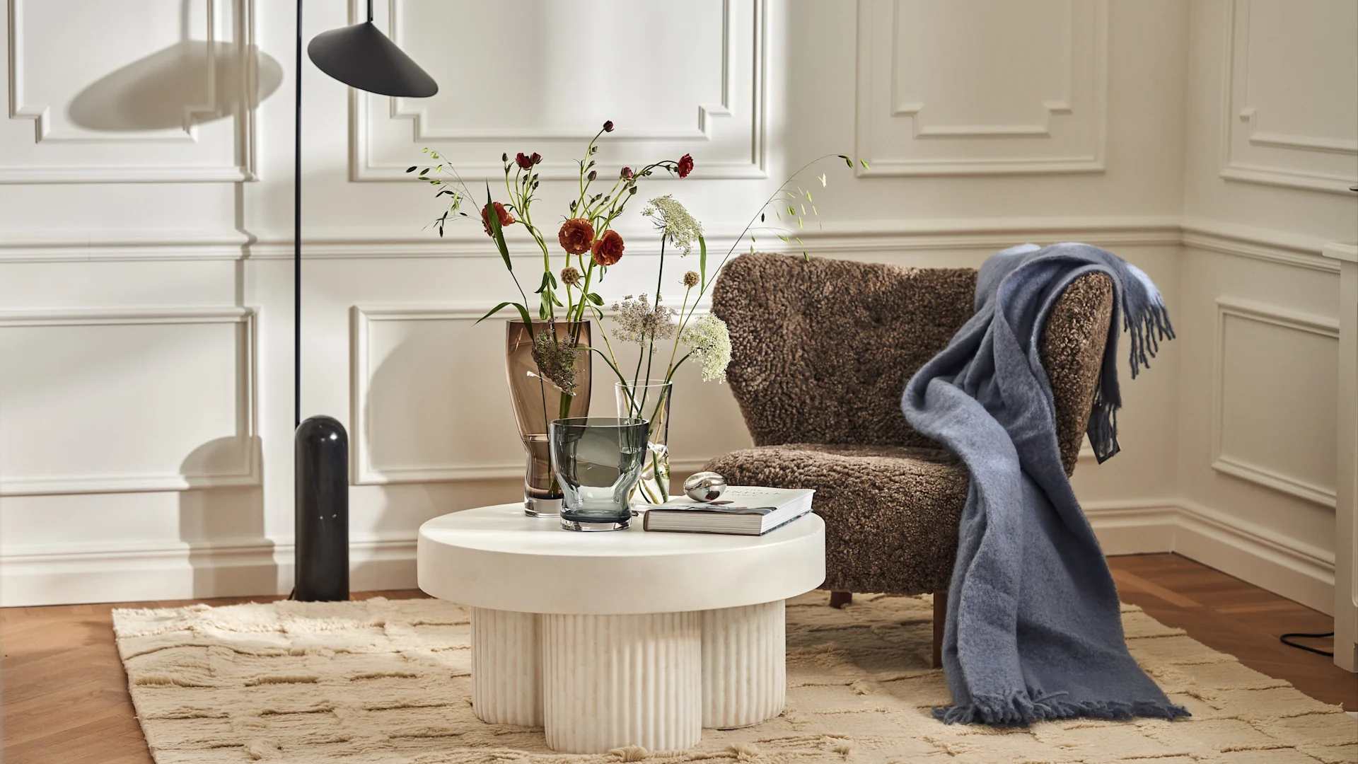 Squeeze-vaser på Gear soffbord från Norr11, Badal matta från Chatwal & Jonsson, Little Petra fåtölj och Stackelberg pläd i färgen plaster.