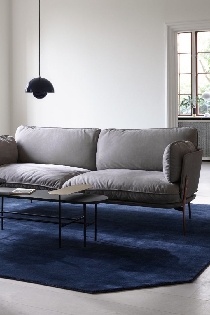Blå matta från &tradition i ett stilrent vardagsrum med grå soffa. 