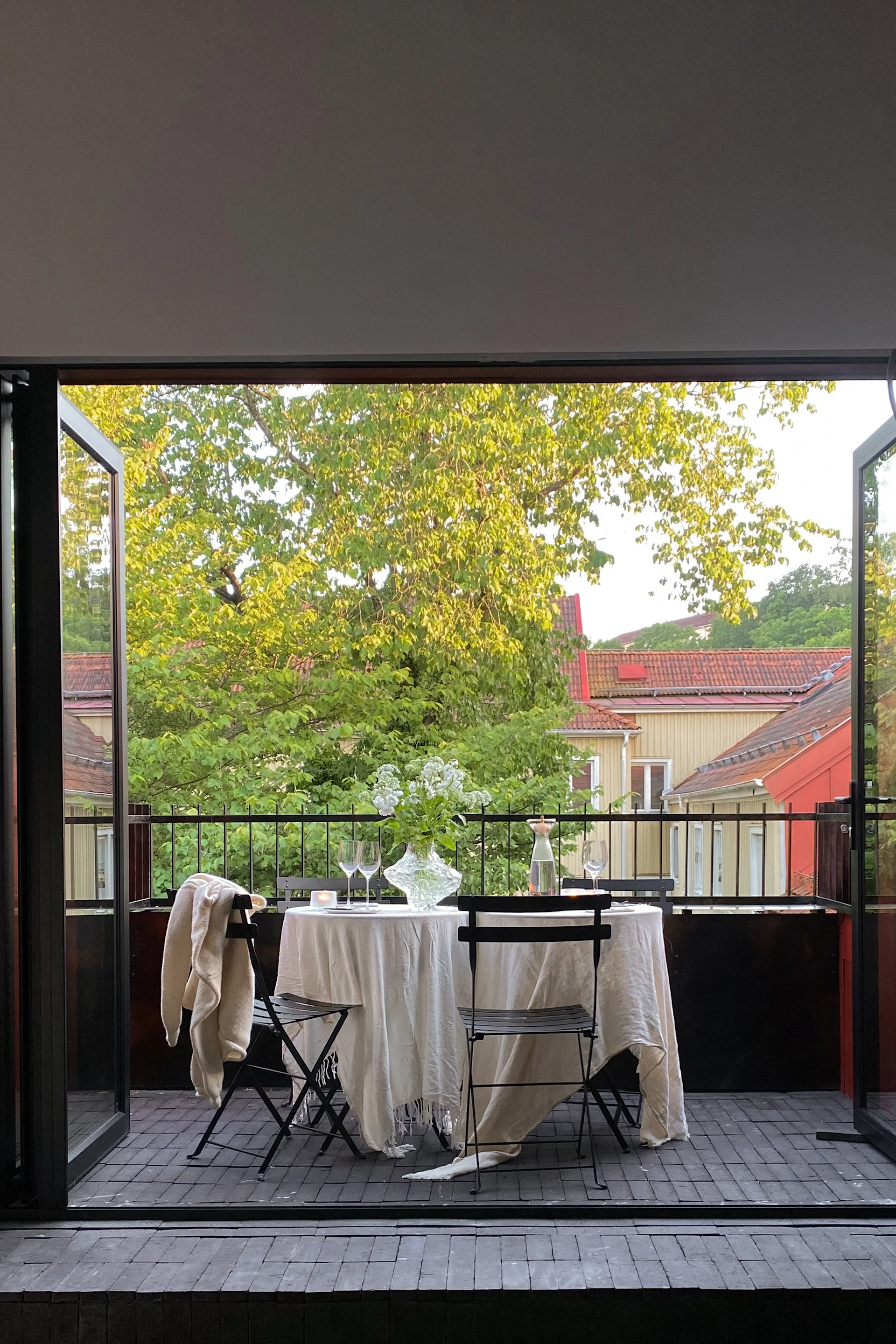 Hemma hos Elin Lannsjö står två Bistro Cafébord och stolar från Fermob placerade på balkongen för att skapa en middagsplats. Genom att inreda balkongen med funktionella möbler kan du enkelt plocka fram och undan vilket ger möjlighet till en balkong med flera olika funktioner.