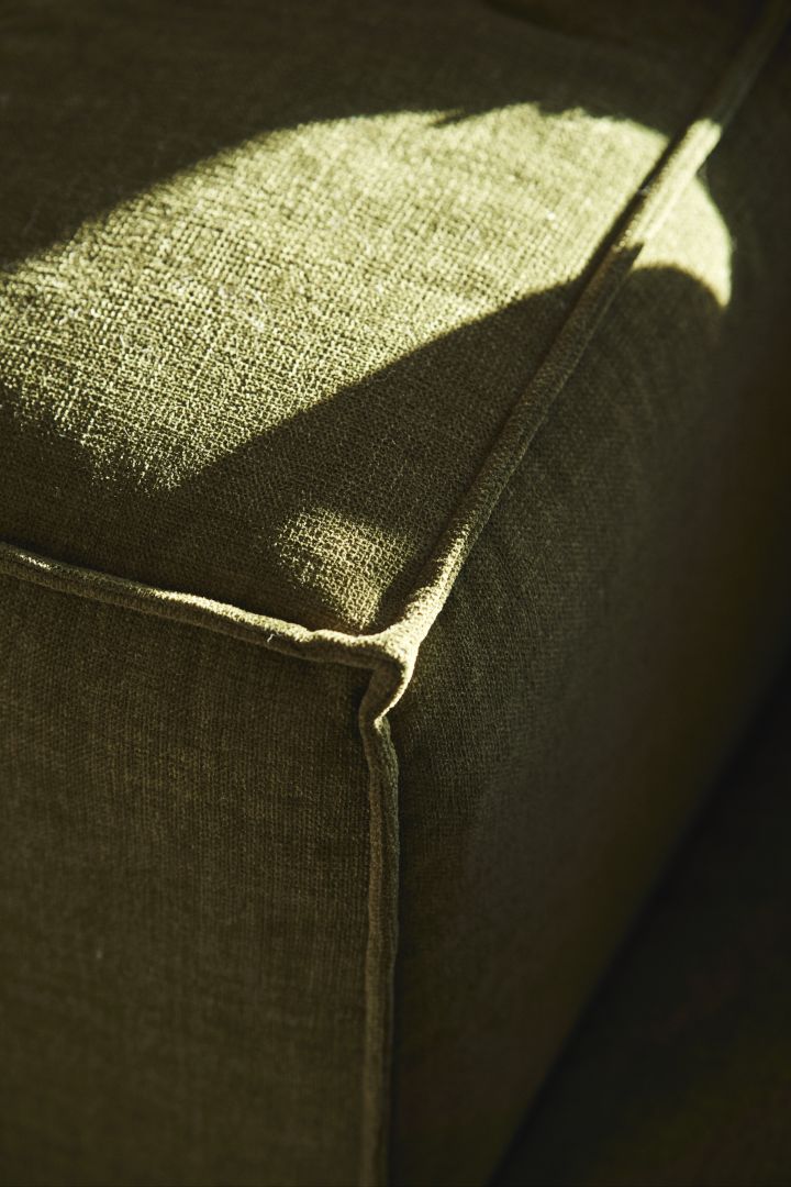 Rengöra soffa i tyg, som denna i grönt kan göras genom att dammsuga den regelbundet, ta bort fläckar med anpassad borttagning och genom att impregnera den.
