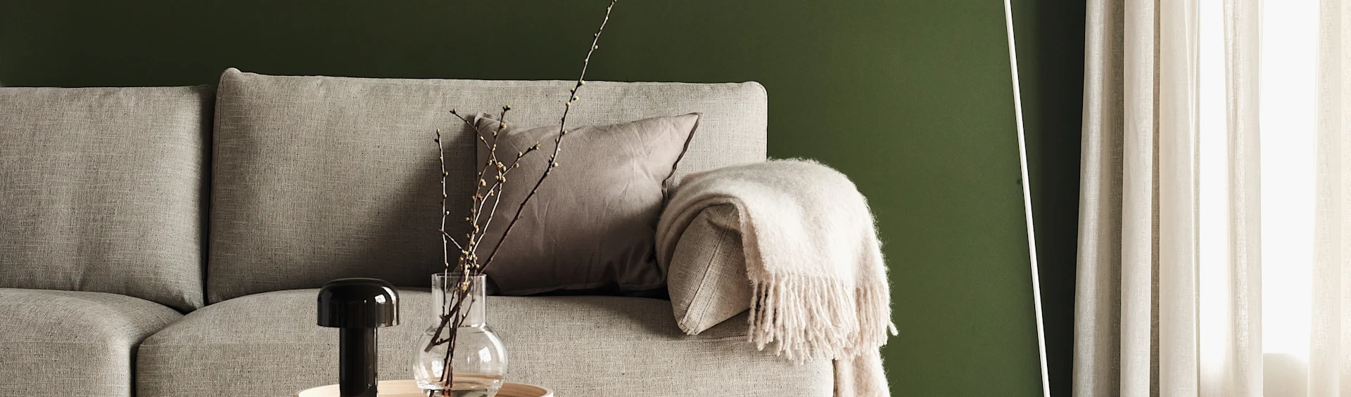 Beige soffa från 1898 med ullpläd och prydnadskudde i linne. 