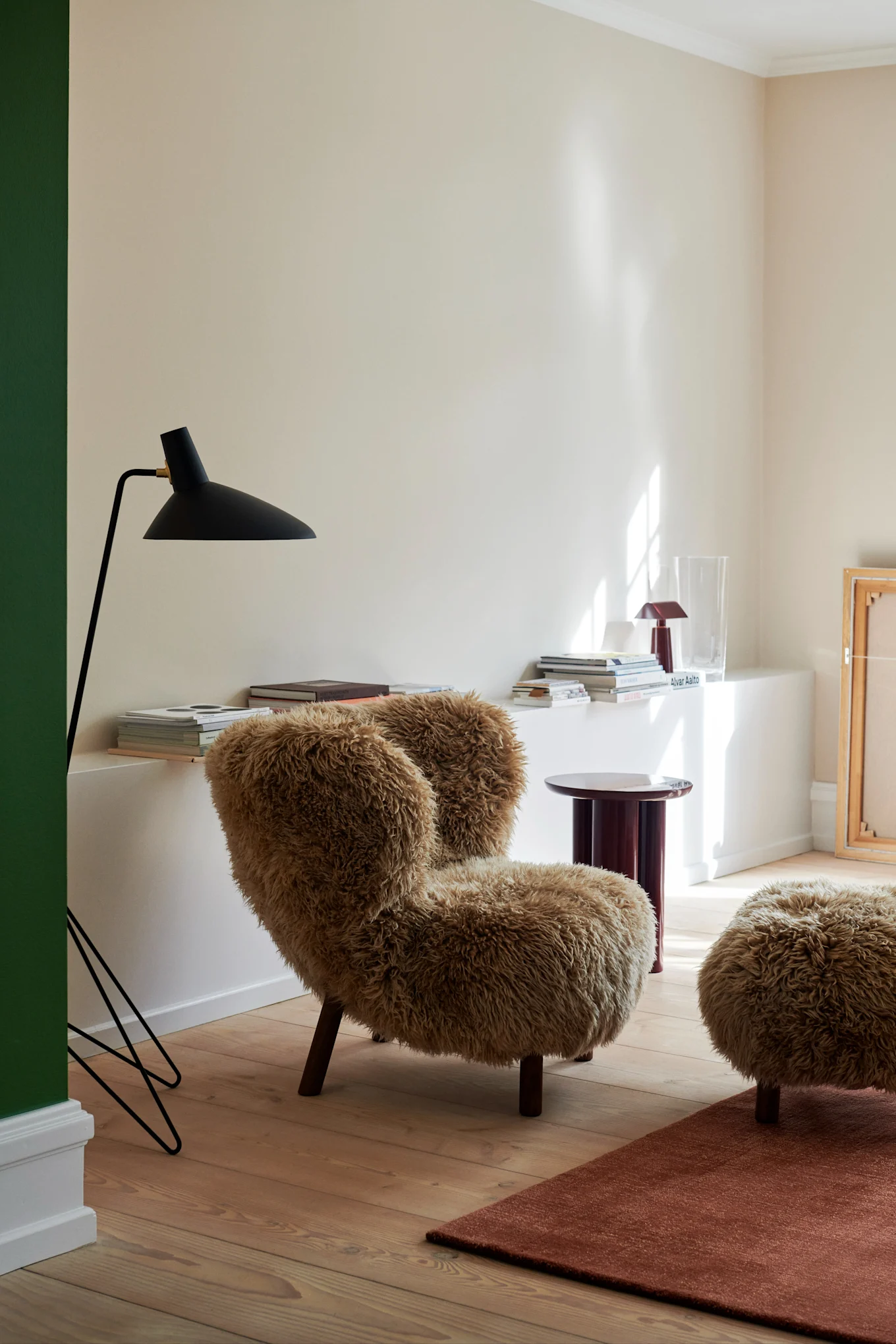 Bild som visar Little Petra VB1 fåtölj i Oljad ek-Sheepskin honey med tillhörande fotpall, här i vardagsrumsmiljö.