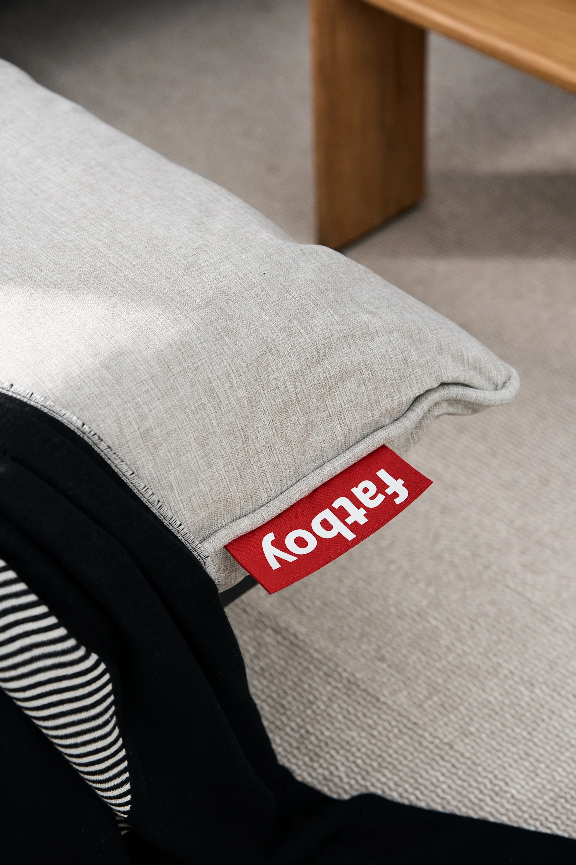 Detaljbild på Paletti modulsoffa från Fatboy, närbild på dynan i färgen mist med Fatboy-logotyp i rött.