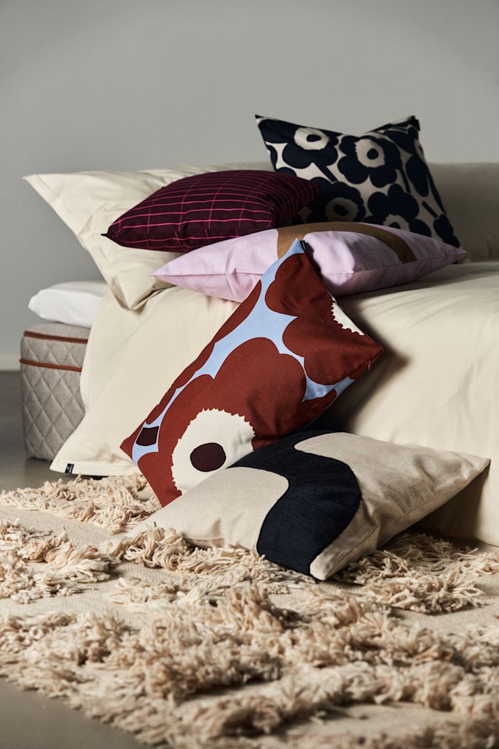 Mönstermixat med kuddar från Marimekko, kuddar i hög med mönster som Unikko och Tilliskiivi.