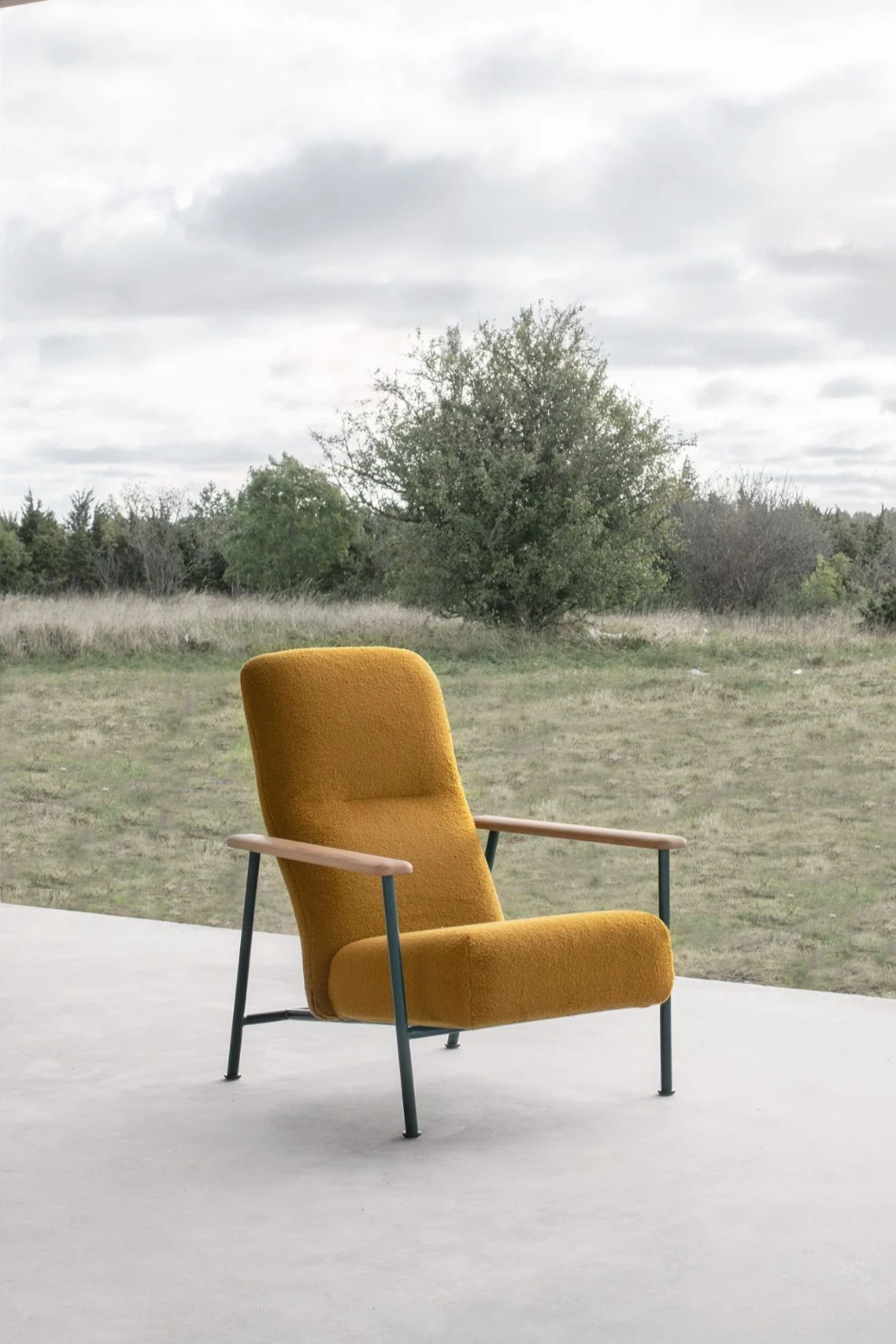 Jump Easy chair fåtölj i gult från Massproductions placerad utomhus på betong