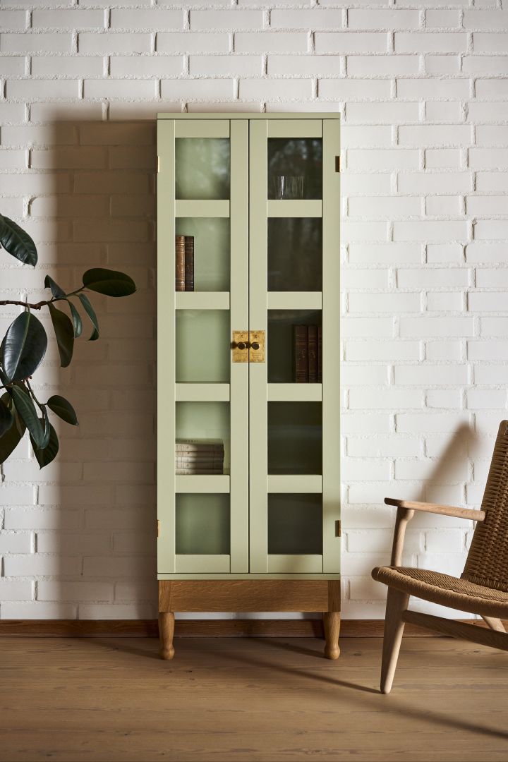 Klassiska möbler som National Geographic skåp i ljusgrönt från Källemo, formgivet av Mats Theselius är en riktig ikon bland svenska designmöbler, här placerat framför vitmålad tegelvägg.