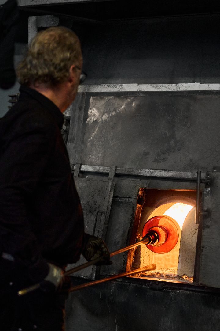 Bild som visar en glasblåsare vid Skrufs Glasbruk när man bränner en vas i ugnen.