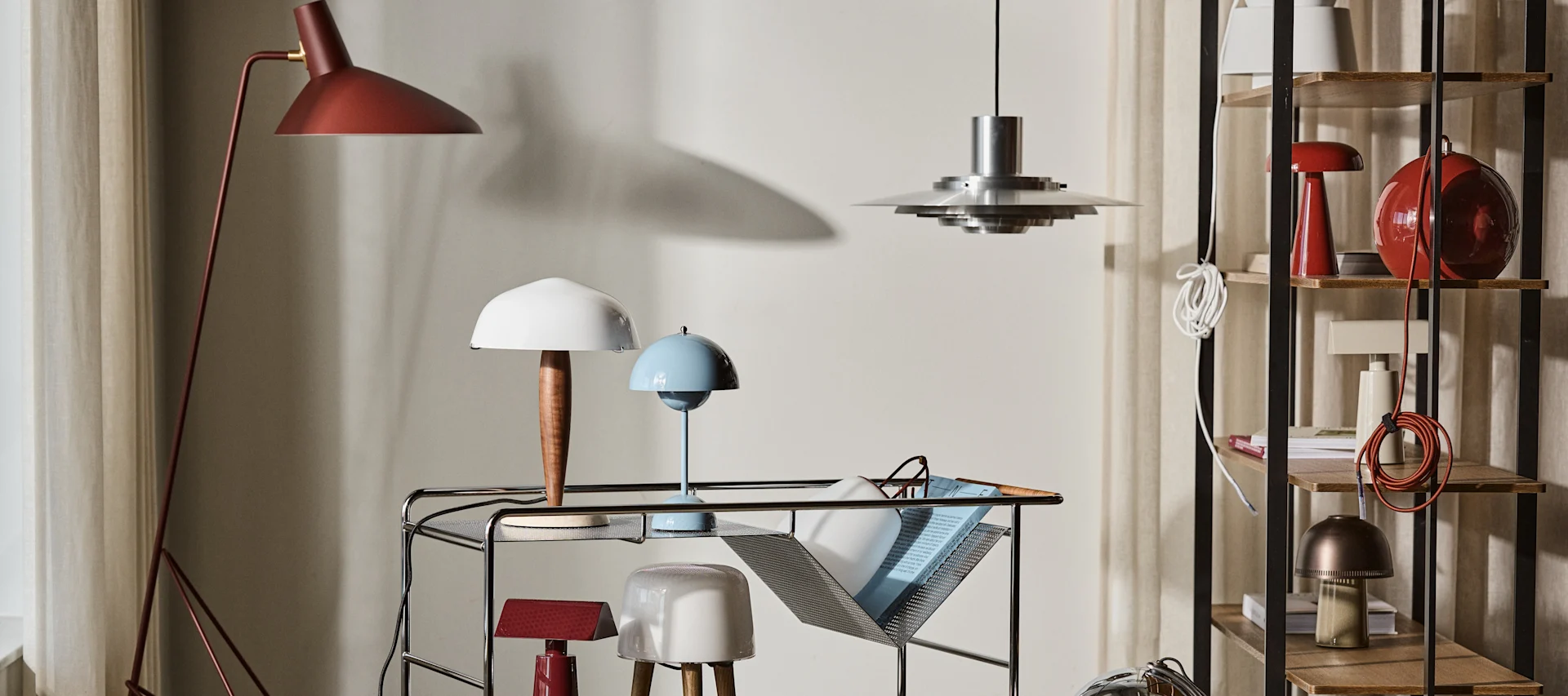 Bild som visar Alima rullvagn från &Tradition tillsammans med Flowerpot lampa i blått, Tripod golvlampa i rött, Herman bordslampa, Milk bordslampa, P376 taklampa och Como portabel bordslampa.
