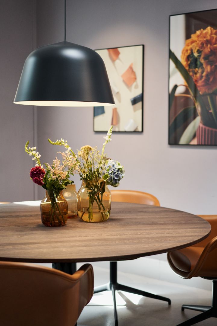Stilgulde höstens inredning 2023, bild som visar Ambit taklampa i svart hängandes över midst bord i rökt ek, på bordet står tre Silent vaser i färgen burnt orange med blommor i. 